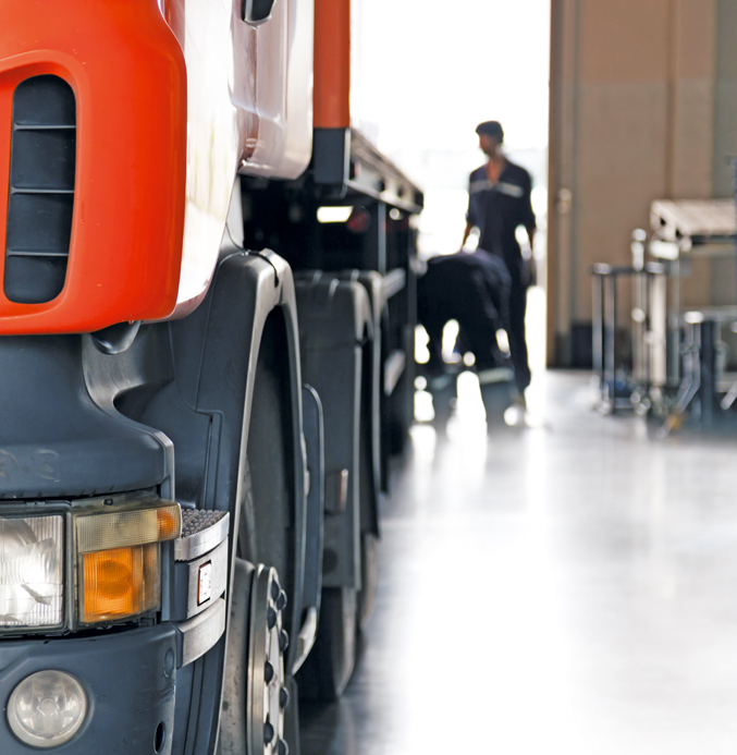 Commercial Truck Maintenance in a Professional Service Workshop Commercial truck undergoing maintenance in a service workshop with technicians inspecting the vehicle.