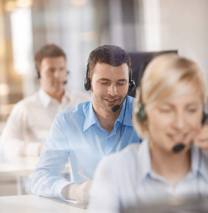 Customer Service Team in a Modern Call Center Customer service team wearing headsets in a bright, modern call center with a soft, artistic focus.