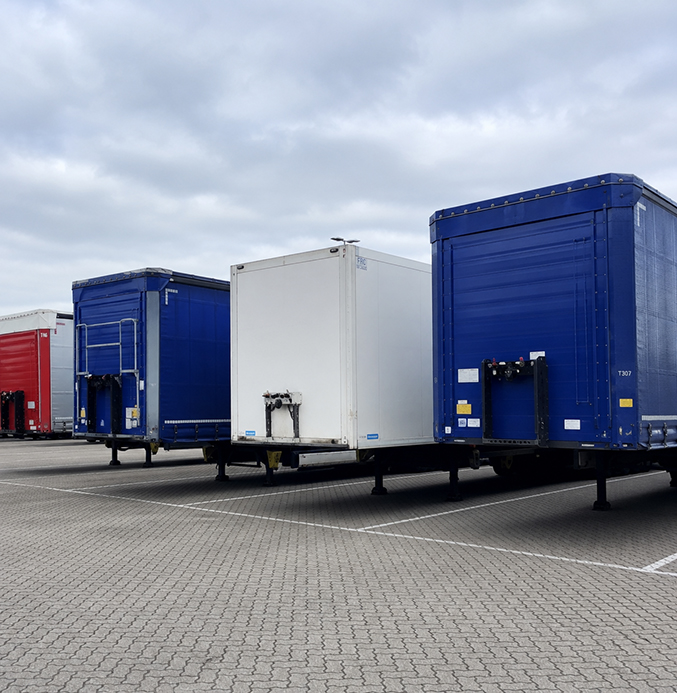 Detached Trailers in an Industrial Parking Lot Several detached semi-trailers parked in an industrial parking lot under an overcast sky.