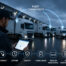 Fleet manager using a tablet to monitor connected trucks and vans, highlighting efficiency, uptime, safety, compliance, trailer monitoring, and EV performance.