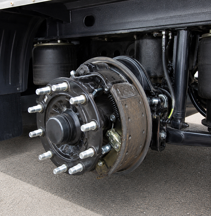 Heavy-Duty Truck Trailer Brake Assembly Close-up of an exposed drum brake assembly on a heavy-duty truck trailer, showing the wheel hub, brake shoes, springs, and suspension components.