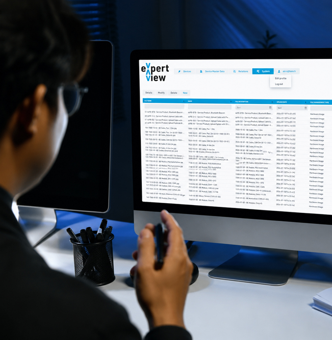 monitor with ExpertView Person viewing the Squarell ExpertView platform on a desktop monitor, displaying a detailed table of vehicle data and system information.